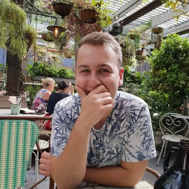 Harrisson Ball laughing at a garden cafe table