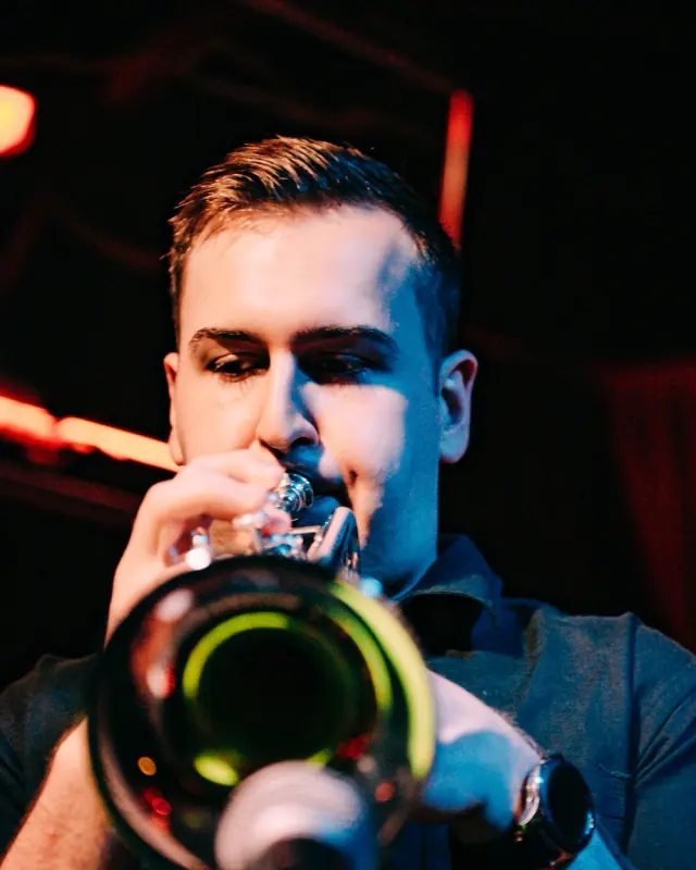 Close-up of Harrisson Ball playing trumpet under blue and red stage light