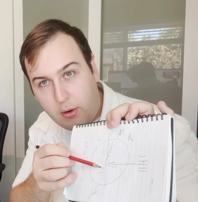 Harrisson Ball holding up a notebook with an embouchure diagram he drew